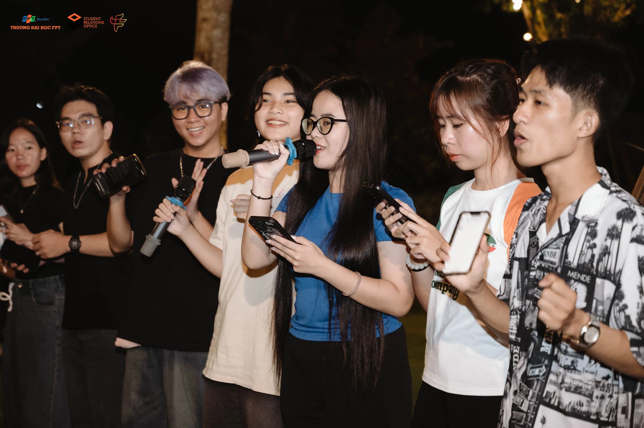 Nhân sự quay phim đang điều chỉnh máy quay trên chân máy tại địa điểm sản xuất